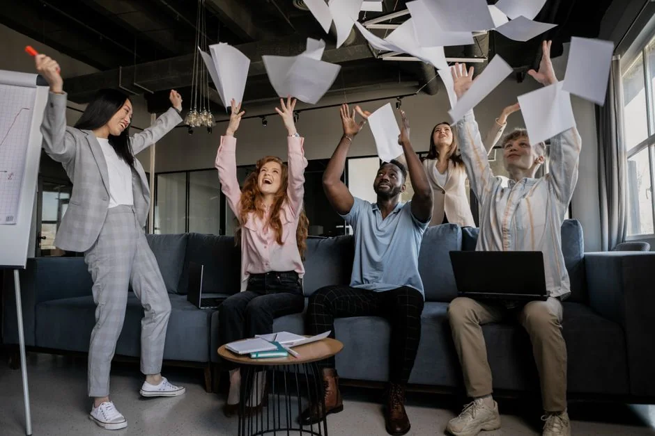 Person analyzes stock data with a smartphone and laptop, indoors.